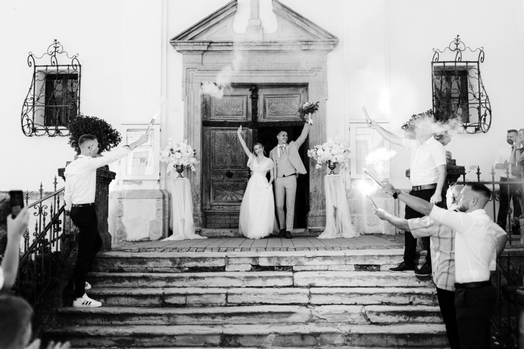 Couple leaving the church while their friends celebrate