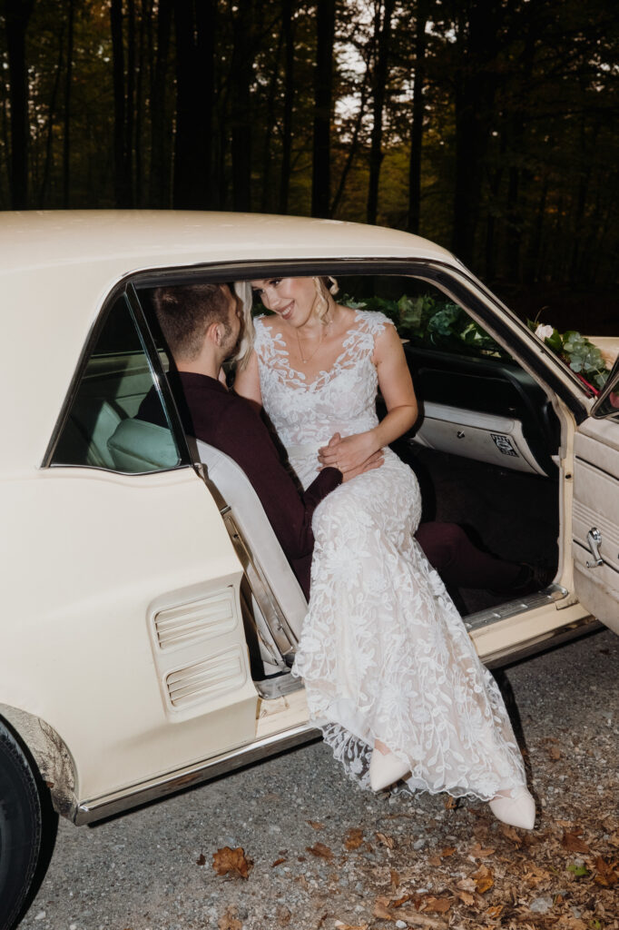 Bride and groom sitting in a Mustang