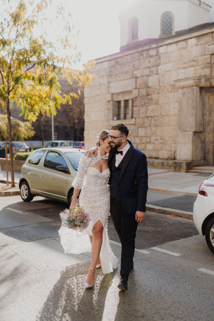 Bride and groom walking and hugging on streets of Zagreb